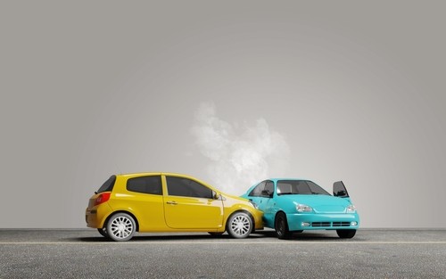 A yellow car has collided with the rear of a blue car, causing visible damage and smoke coming from the blue car's hood.